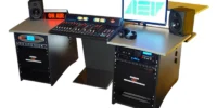 AEV Synapse Digital radio studio package with modular Synapse broadcast console, dual rack cabinets, studio monitors, On Air light and computer workstation on grey desk.